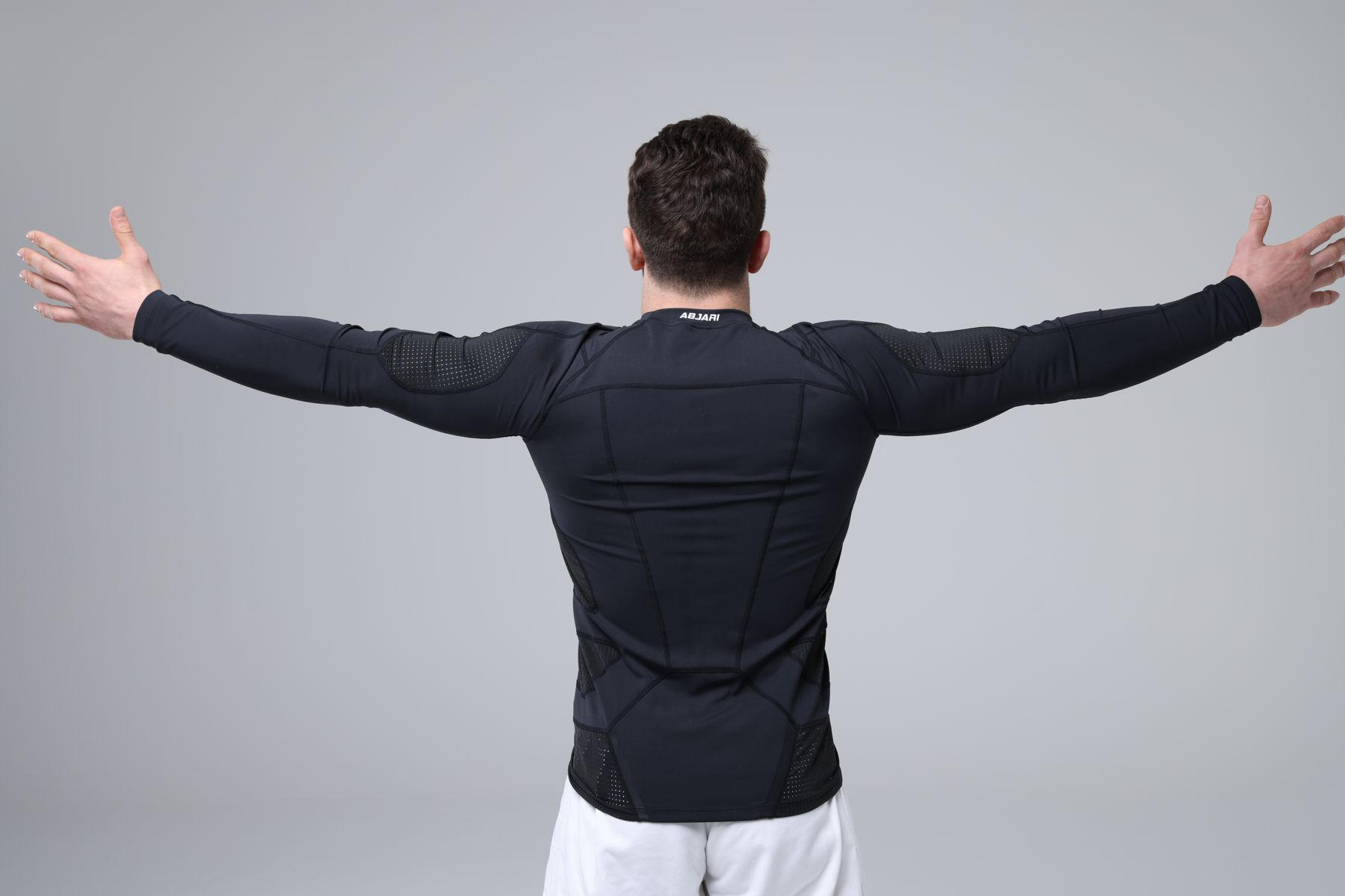 Athlete in an Abjari compression long sleeve, arms spread wide