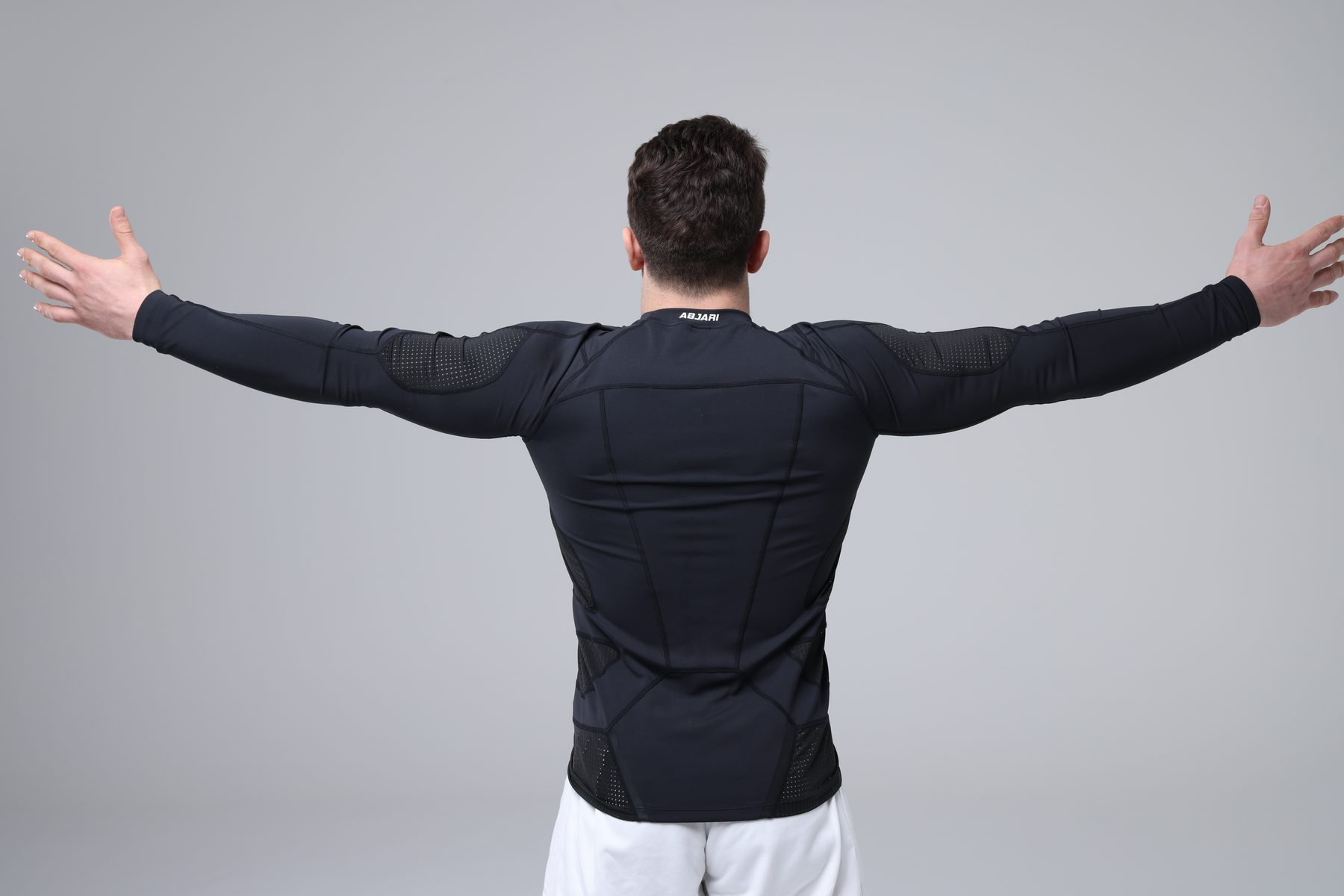 Athlete in an Abjari compression top with arms spread wide